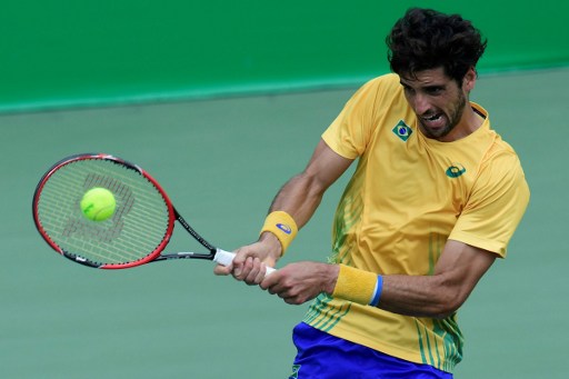 Thomaz Bellucci hits a backhand to David Goffin during their third round match in Rio/Photo: Javier Soriano/AFP