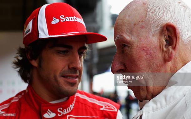 Surtees converses with Fernando Alonso at the 2010 Belgian Grand Prix. | Photo: Getty Images/Vladimir Rys