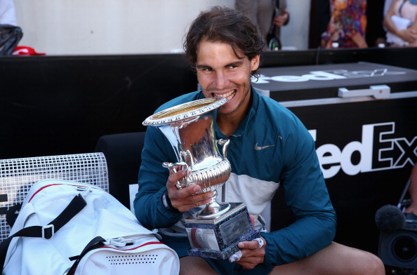 Rafael Nadal bites his seventh Internazionali BNL D'Italia trophy in Rome/Getty Images