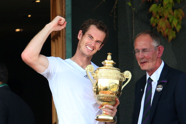 Andy Murray celebrates on the Centre Court balcony as he holds the Gentlemen's Singles Trophy following his victory against Novak Djokovic in Wimbledon. (Photo by Julian Finney/Getty Images)