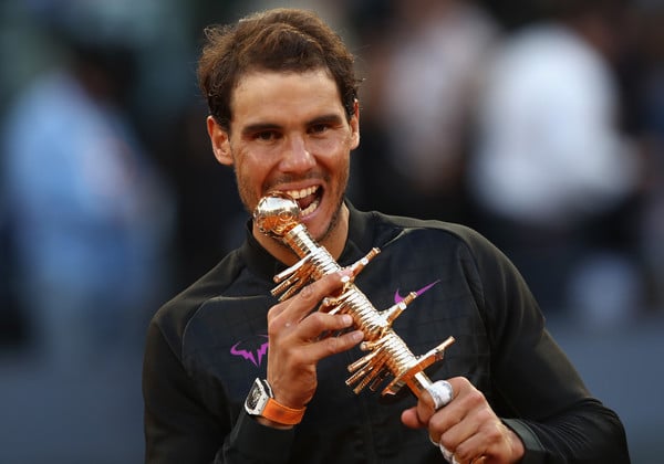 Rafael Nadal bites into his fifth Madrid trophy in 2017. He'll look to add a sixth this week. Photo: Julian Finney/Getty Images