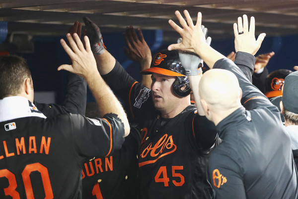 Mark Trumbo #45 of the Baltimore Orioles celebrates with teammates in the dugout after hitting a two-run home run in the fourth inning against the Toronto Blue Jays during the American League Wild Card game at Rogers Centre on October 4, 2016 in Toronto, Canada. (Oct. 3, 2016 - Source: Tom Szczerbowski/Getty Images North America)