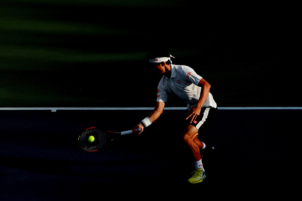 Kei Nishikori returns a shot to Ivo Karlovic (Photo: Michael Reaves/Getty Images)
