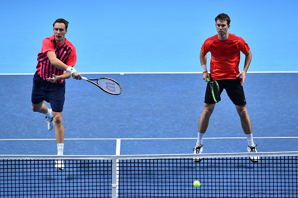 Henri Kontinen returns a forehand shot to the Bryan B?rothers with partner John Peers watching on (Photo: Glyn Kirk/Getty Images)