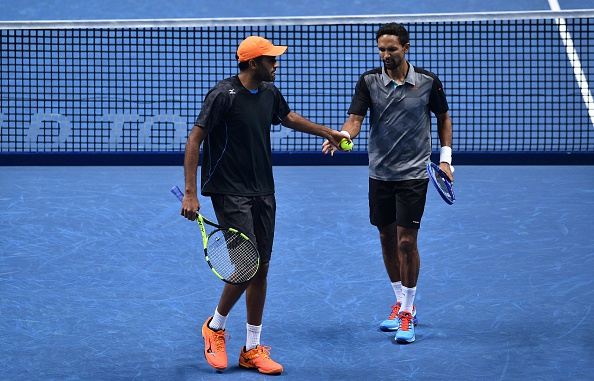 Raven Klaasen and Rajeev Ram touch hands between points against Jamie Murray and his partner Bruno Soares (Photo: Glyn Kirk/Getty Images)