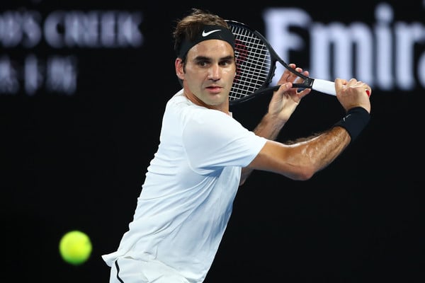 Roger Federer lunges to hit a backhand slice against Marin Cilic during the final of the 2018 Australian Open. | Photo: Clive Brunskill/Getty Images