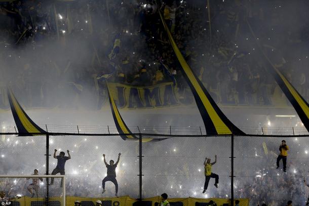 Capos lead Boca Juniors fans in pyrotechnic-filled choreography and cheers ahead of the team's return leg match against River Plate in the 2015 Copa Libertadores round of 16. (Photo credit: Associated Press)