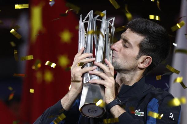 Novak Djokovic kisses his record-breaking fourth trophy in Shanghai. Photo: Andy Wong/AP