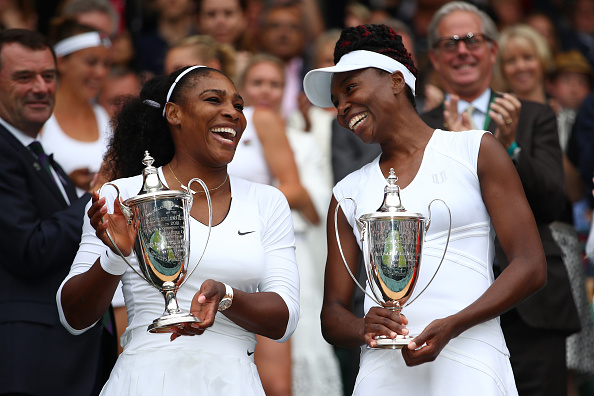 Serena (left) and older sister Venus (right) celebrate their 14th Grand Slam doubles title together. Photo credit: Clive Brunskill/Getty Images.
