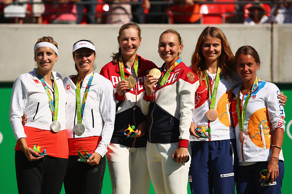 From left to right: Silver medallists Timea Bacsinszky and Martina Hingis, gold medallists Ekaterina Makarova and Elena Vesnina and bronze medallists Lucie Safarova and Barbora Strycova on the podium after winning medals in women's doubles. Photo credit: Clive Brunskill/Getty Images.