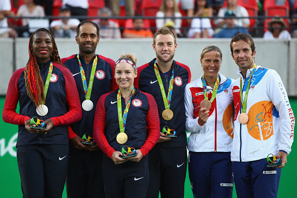 From left to right: Silver medallists Timea Bacsinszky and Martina Hingis, gold medallists Ekaterina Makarova and Elena Vesnina and bronze medallists Lucie Safarova and Barbora Strycova on the podium after winning medals in mixed doubles. Photo credit: Clive Brunskill/Getty Images.