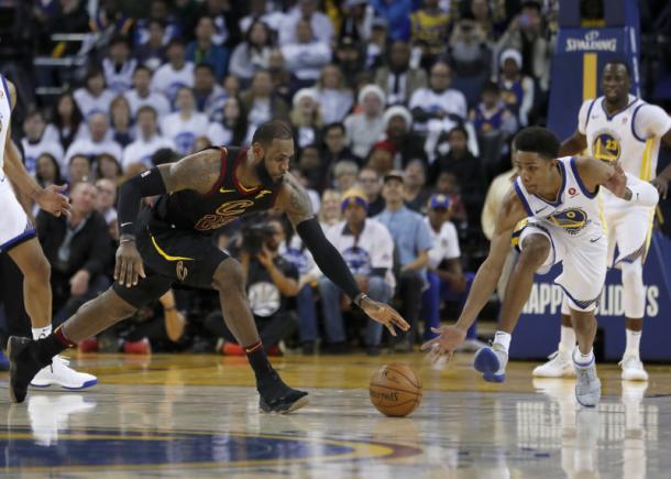 James battles with Golden State's Patrick McCaw for a loose ball during the Cavaliers-Warriors Christmas Day game/Photo: Tony Avelar/Getty Images