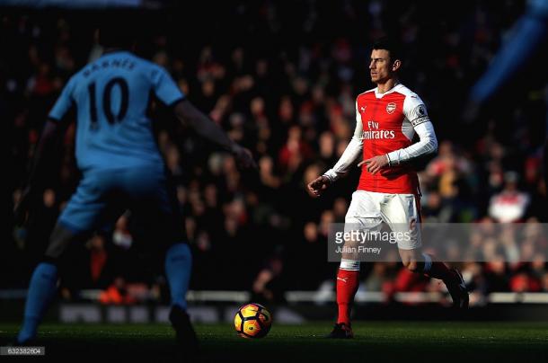 Laurent Koscielny is monitored by Ashley Barnes. | Photo: Getty Images/Julian Finney