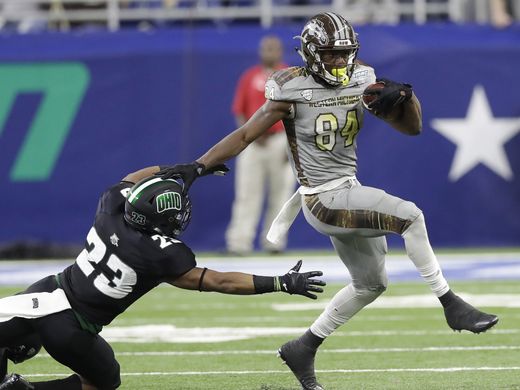 Western Michigan wide receiver Corey Davis (r.) eludes Ohio safety Kylan Nelson (l.) during the first half of the MAC Championship Game/Photo: Carlos Osorio/Associated Press