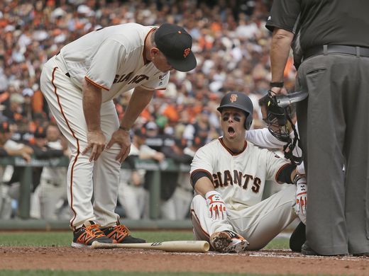 Giants manager Bruce Bochy, left, checks Buster Posey on the ground after he was hit by a Taijuan Walker pitch in the first inning of Monday's game. (Photo: Eric Risberg/AP)