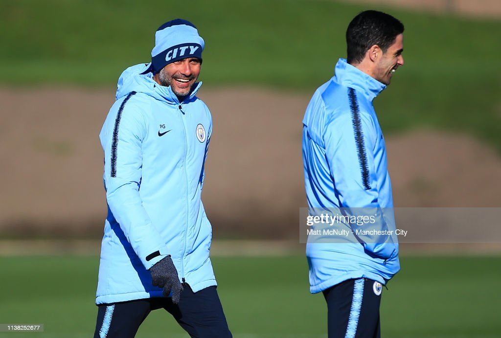 Pep Guardiola, manager of Manchester City shares a joke with assistant coach Mikel Arteta during the training session at Manchester City Football Academy on March 25, 2019 in Manchester, England. (Photo by Matt McNulty - Manchester City/Manchester City FC via Getty Images)
