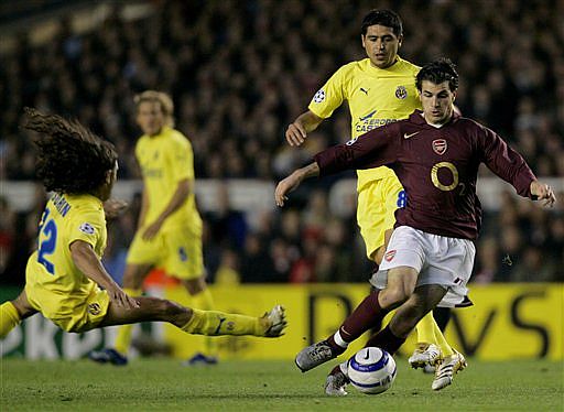 Cesc Fàbregas se lleva el balón frente a Sorín (izquierda) y Riquelme | AP Photo