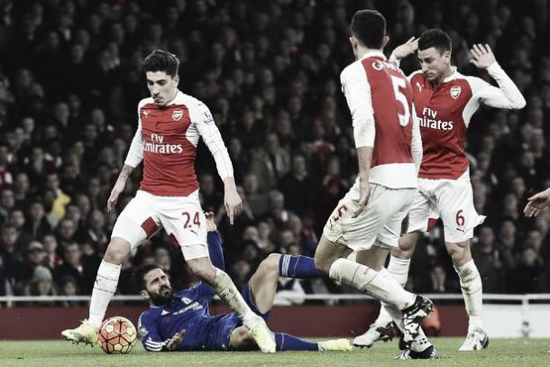 Cesc Fabregas body-checked by Laurent Koscielny | Photo: Getty Images