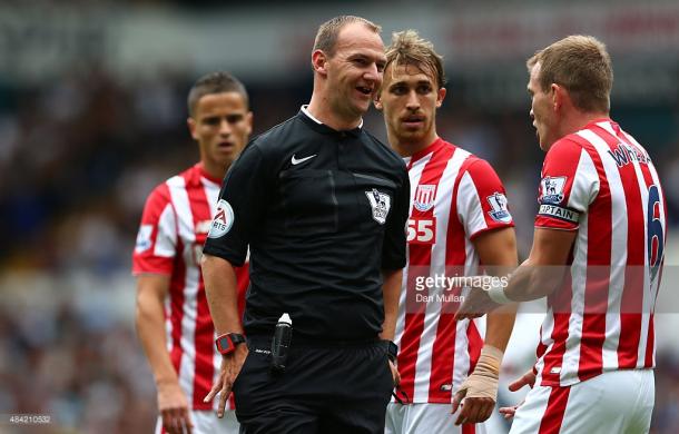 Madley prepares to issue a yellow card. Source | Getty Images.