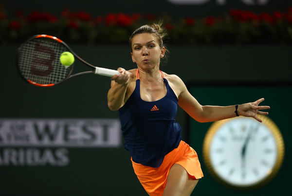 Simona Halep returns a serve | Photo: Clive Brunskill/Getty Images North America