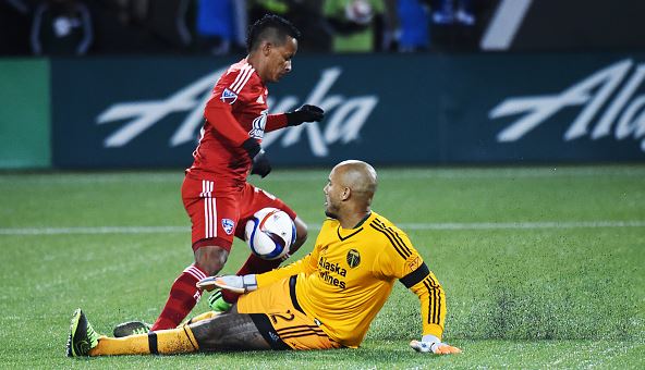 Goal keeper Adam Kwarasey #12 of Portland Timbers slides in on Michael Barrios #21 of FC Dallas during the second half of the match at Providence Park on November 22, 2015 in Portland, Oregon. (Photo by Steve Dykes/Getty Images