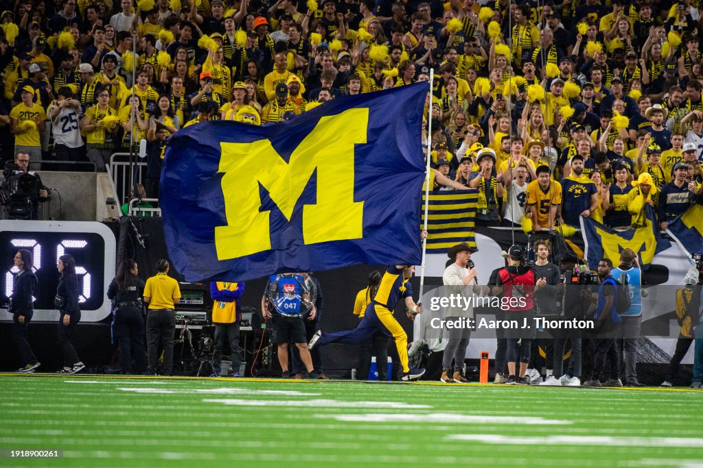 The Michigan Wolverines flag is carried across the field in celebration after a touchdown during the second half of the 2024 CFP National Championship game against the Washington Huskies at NRG Stadium on January 08, 2024 in Houston, Texas. The Michigan Wolverines won the game 34-13. (Photo by Aaron J. Thornton/Getty Images)