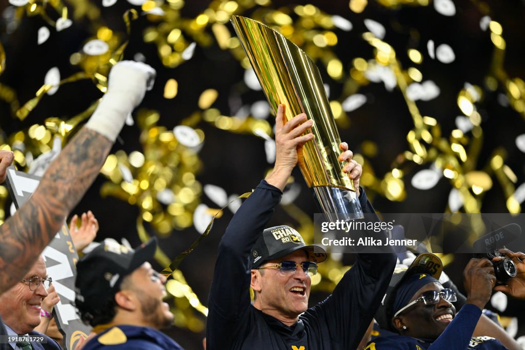 Head coach Jim Harbaugh of the Michigan Wolverines holds up the College Football Playoff National Championship Trophy after the 2024 CFP National Championship game against the Washington Huskies at NRG Stadium on January 08, 2024 in Houston, Texas. The Michigan Wolverines won 34-13. (Photo by Alika Jenner/Getty Images)