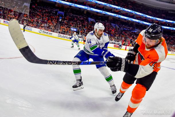 Sean Couturier (14) clears the puck past Erik Gudbranson in Vancouver's 5-2 win on November 21, 2017.              (Photo credit: SB Nation)