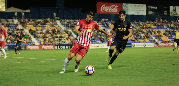 El Almería intenta sacar el esférico ante la presión rival. (Foto: UCAM Murcia CF).