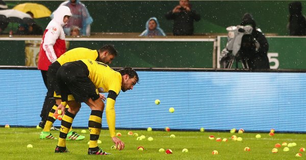 The travelling Dortmund fans make their thoughts known, by throwing tennis balls onto the pitch?!