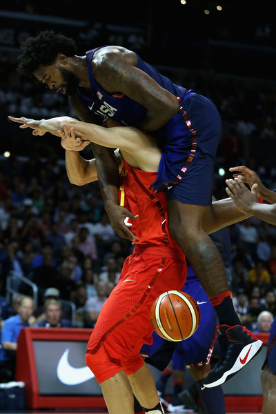 Team USA's DeAndre Jordan trying to keep the ball alive while jumping over China's Yi Jianlian. Photo: Sean M. Haffey/Getty Images North America