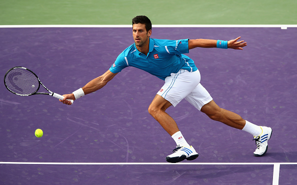 Djokovic rushes to the net to hit the volley. Credit: Clive Brunskill/Getty Images