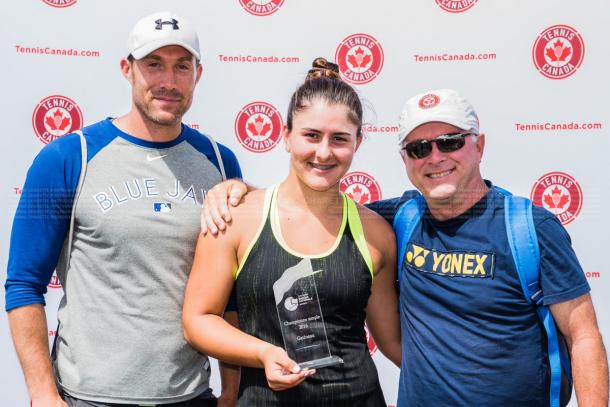 Bianca Vanessa Andreescu poses with her team and the winner’s trophy after winning the 2016 Challenger Banque Nationale de Saguenay. | Photo: Dominic Charette Photography