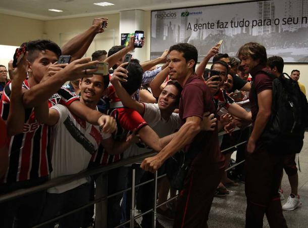 Hernanes e Lugano no desembarque da delegação no aeroporto de Goiana Divulgação: Twitter Oficial do São Paulo Futebol Clube
