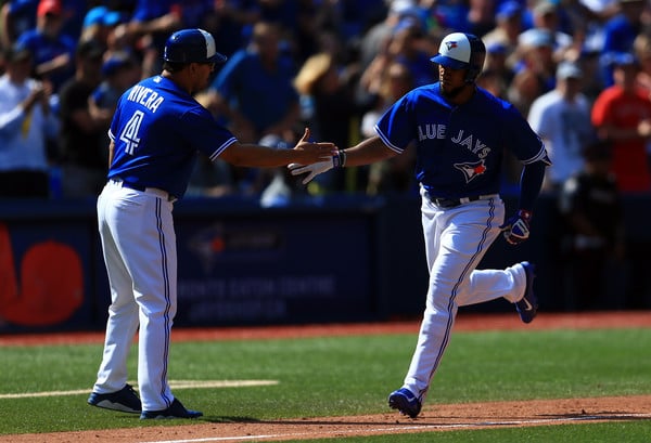 Teoscar Hernandez is congratulated by Blue Jays third base coach Luis Rivera after hitting his second home run of the day. | Photo: Vaughn Ridley/Getty Images