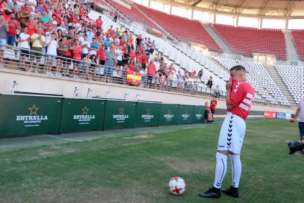 Dani Aquino besando el escudo del Real Murcia ante la mirada de los aficionados. Foto: Real Murcia