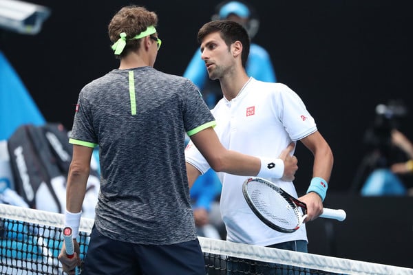 Djokovic (left) shakes hands with Denis Istomin following his shocking second-round loss in Melbourne. Photo: Scott Barbour/Getty Images