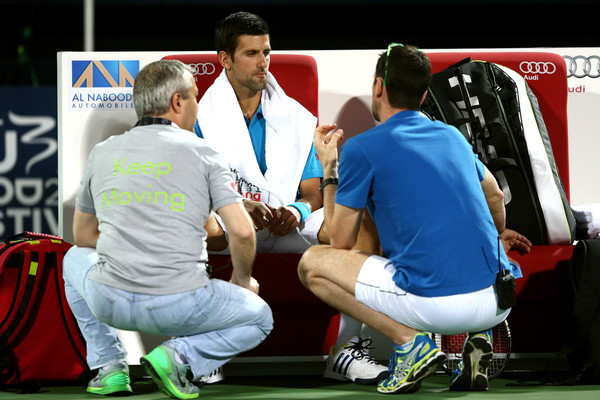 Novak Djokovic (center) receives medical attention during his quarterfinal match. Photo: Warren Little/Getty Images