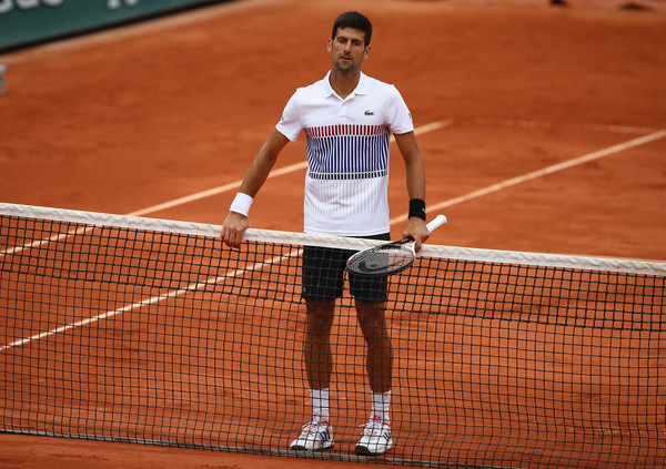 Djokovic waits alone at the net after his quarterfinal loss at the French Open, where he was the defending champion and had reached three straight finals. Photo: Clive Brunskill/Getty Images