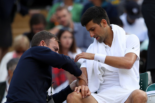 Djokovic receives treatment on his elbow during the Wimbledon quarterfinal. Photo: Julian Finney/Getty Images