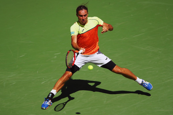 Alexandr Dolgopolov slides into a forehand during his fourth-round loss. Photo: Clive Brunskill/Getty Images