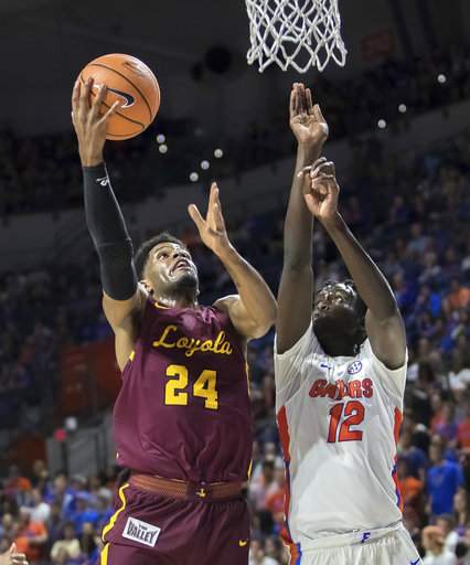 Loyola's Aundre Jackson shoots a layup over Florida's Gorjok Gak during the Ramblers' win/Photo: Ron Irby/Getty Images