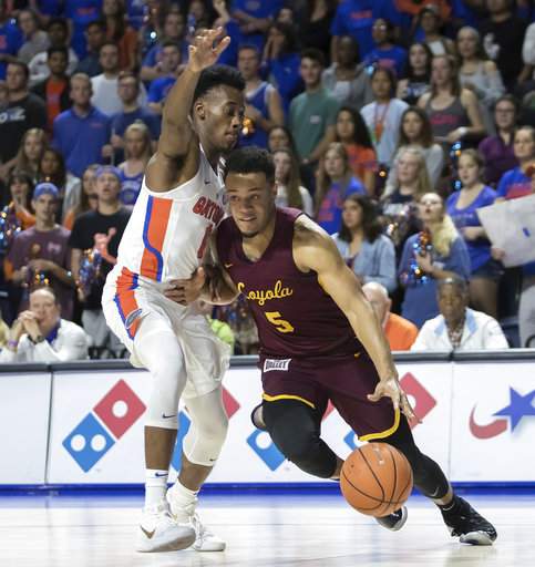 Loyola's Marques Townes drives past Florida's Mark Okauru during Wednesday night's game/Photo: Ron Irby/Associated Press