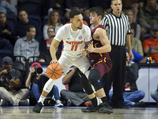 Chris Chiozza of Florida tries to drive against Loyola's Clayton Custer during last night's game in Gainesville/Photo: Ron Irby/Associated Press