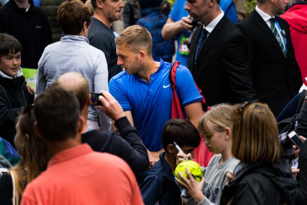 Evans celebrates victory as he signs autographs for the fans. Photo: LTA