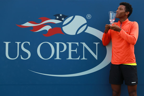 Félix Auger-Aliassime kisses the winner’s trophy after defeating Miomir Kecmanovic in the boys’ singles final of the 2016 U.S. Open. | Photo: Michael Reaves/Getty Images North America