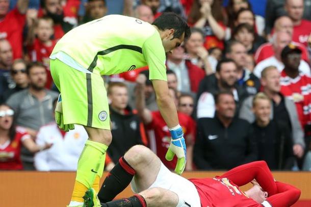 Bravo looks on worryingly as Rooney is hurt after his tackle in the box | Photo: Getty