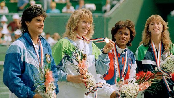 Graf (second from the left) holds up her Olympic Gold Medal after beating Sabatini (left) in the final. Photo: AP/Lionel Cironneau