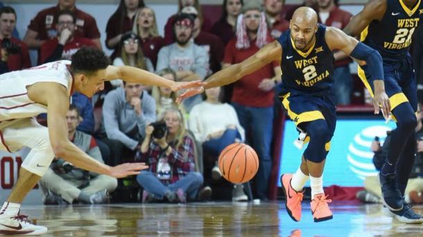 Carter knocks the ball away from Oklahoma's Jamuni McNeace during West Virginia's victory in Norman/Photo: Kyle Phillips/Associated Press