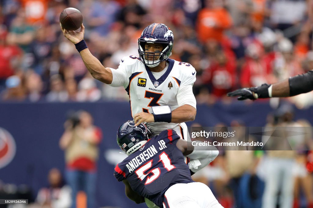 Russell Wilson #3 of the Denver Broncos throws a pass while being tackled by Will Anderson Jr. #51 of the Houston Texans in the second quarter at NRG Stadium on December 03, 2023 in Houston, Texas. (Photo by Carmen Mandato/Getty Images)